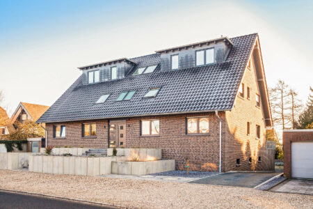Ein 6-Familien-Haus in Kleve mit Fenstern im Mauerwerk und Dachgaube - farblich perfekt an den Schiefer angepasst
