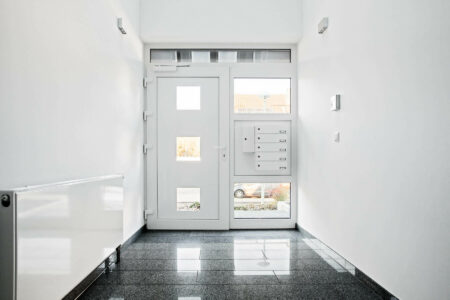 Innenansicht einer Haustüre in einem Mehrfamilienhaus mit integrierter Briefkastenanlage - Innen weiß, außen Basaltgrau